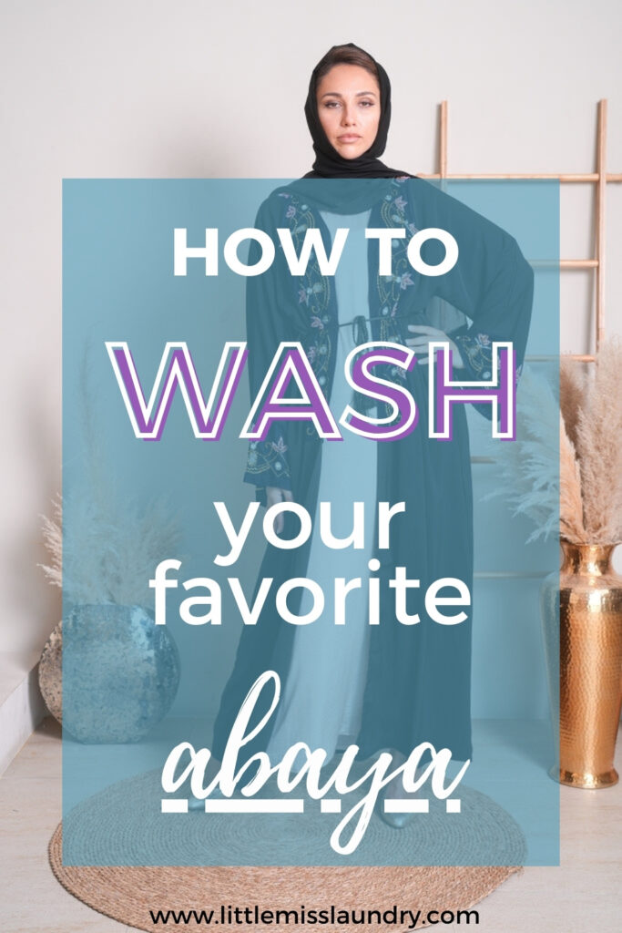 A solemn-looking woman in a detailed blue abaya and black hijab stands in an indoor setting with decor elements, overlaid with vibrant text saying 'HOW TO WASH your favorite abaya' and the website 'littlemisslaundry.com' below.
