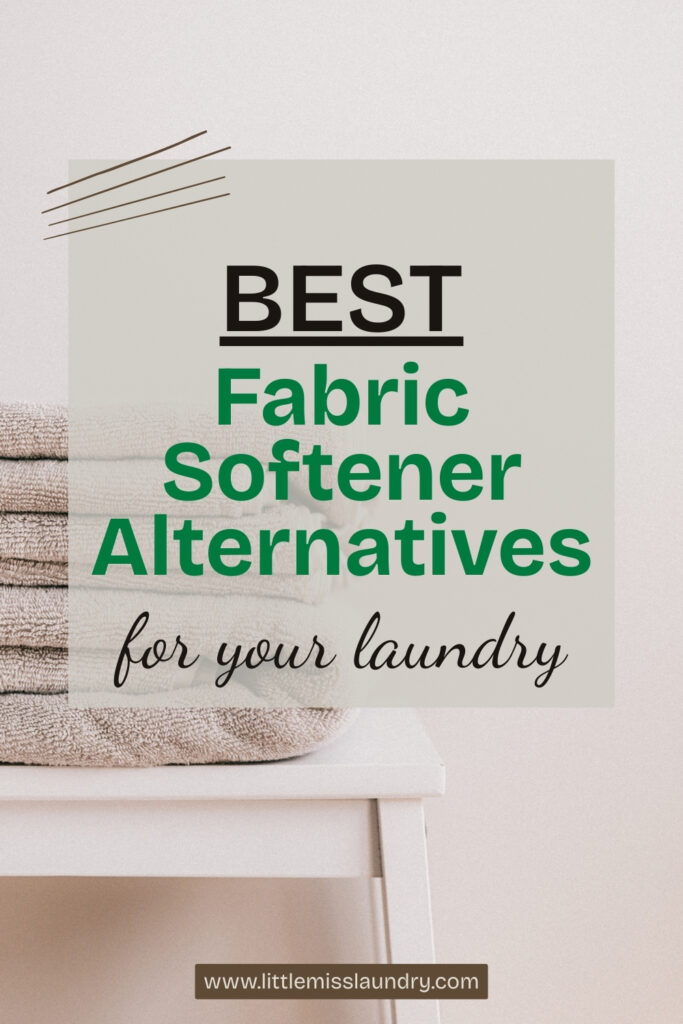 Stack of beige towels neatly folded on a white stool next to a soft gray wall, with text overlay reading "Best Fabric Softener Alternatives for your laundry" and a website link at the bottom.