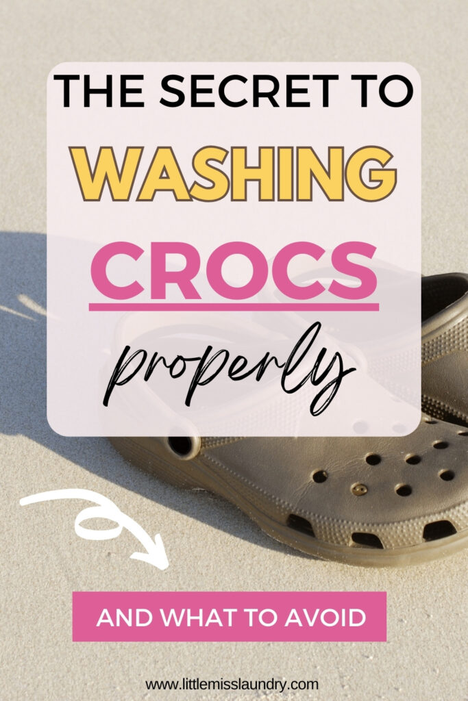 Brown Crocs resting on light sand with a text overlay that reads "The secret to washing Crocs properly and what to avoid." An arrow points toward the shoes, emphasizing the focus of the cleaning tips.
